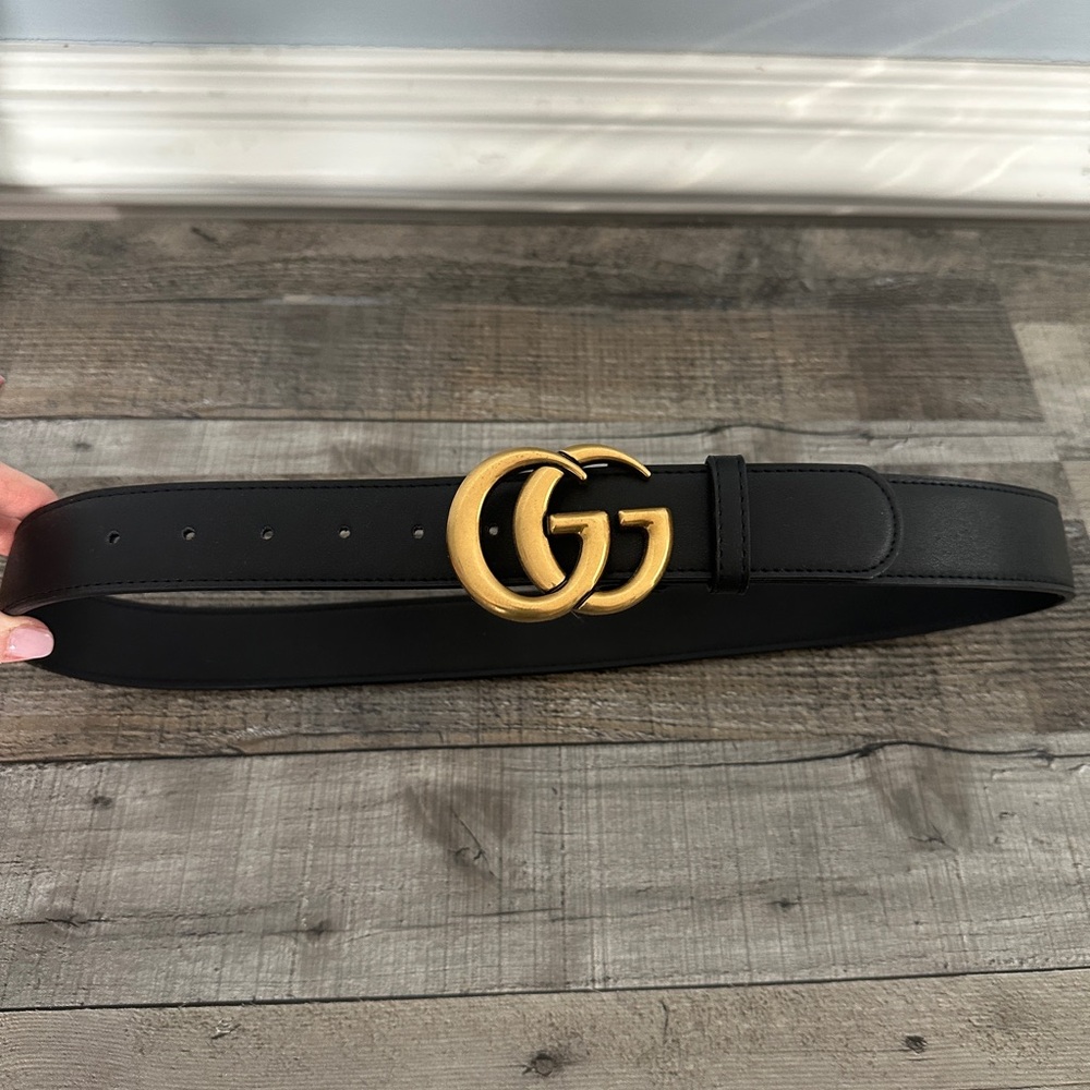 Black leather belt with gold double G.